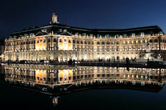 Les façades éclairées se reflettent dans le miroir d'eau